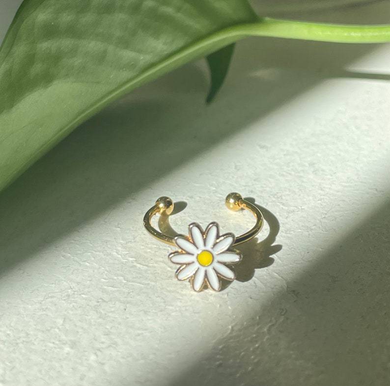 Gold Plated Copper Ring Featuring A Small Daisy Design Rotating Mechanism And Adjustable Opening For Versatile Jewelry