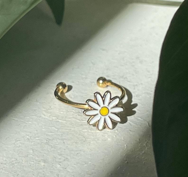 Gold Plated Copper Ring Featuring A Small Daisy Design Rotating Mechanism And Adjustable Opening For Versatile Jewelry